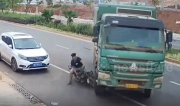 May mắn thoát chết sau khi phi cả người lẫn xe vào gầm ô tô tải