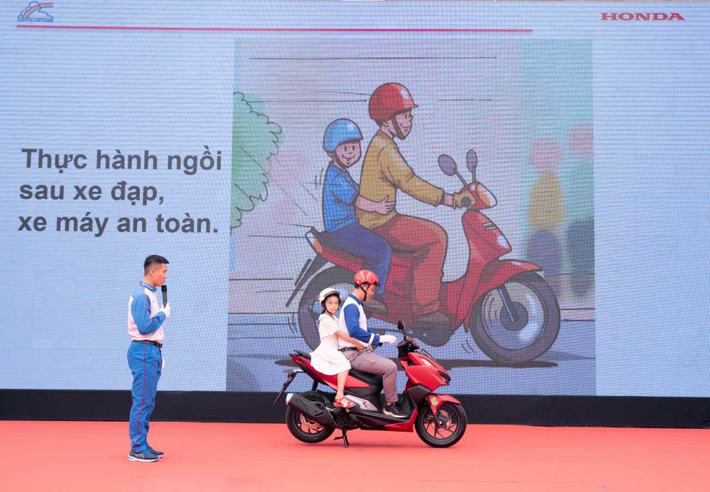 Hướng dẫn viên Honda Việt Nam hướng dẫn tư thế ngồi trên xe máy an toàn cho các em học sinh 