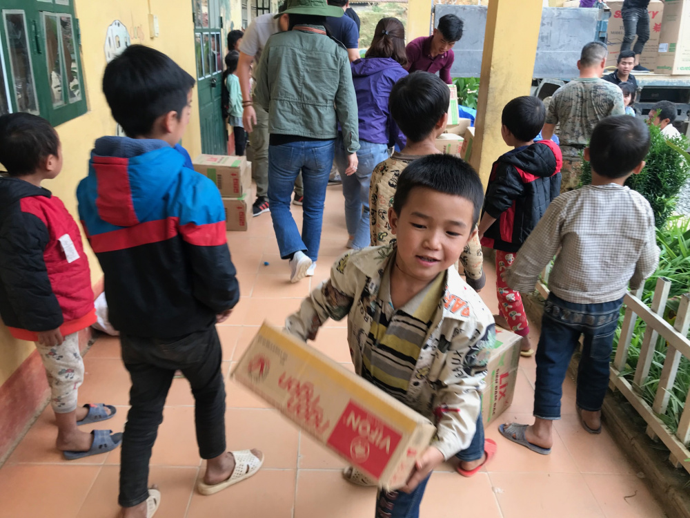 Tụi trẻ hồn nhiên, trong trẻo nhiệt tình khuân vác quà của đoàn từ thiện