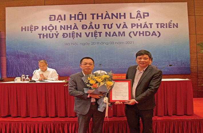 Ông Tạ Tấn - Phó Vụ trưởng Vụ Tổ chức Phi chính phủ trao Quyết định và hoa cho ông Lương Minh Tuấn - đại diện Hiệp hội VHDA