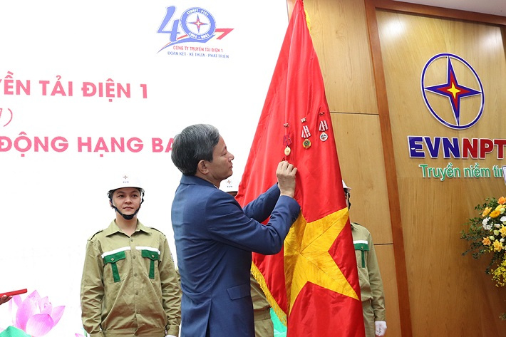Tổng giám đốc EVN Trần Đình Nhân thừa ủy quyền của Chủ tịch nước gắn Huân chương Lao động hạng Ba lên lá cờ Tổ quốc, phần thưởng cao quý Đảng và Nhà nước trao tặng Công ty Truyền tải điện 1