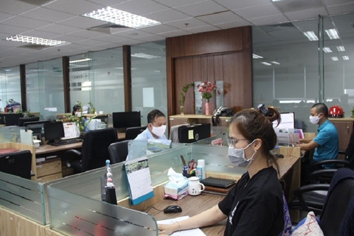 Các kỹ sư Trung tâm phát triển phần mềm thuộc EVNICT tuân thủ giãn cách và đeo khẩu trang trong giờ làm việc.
