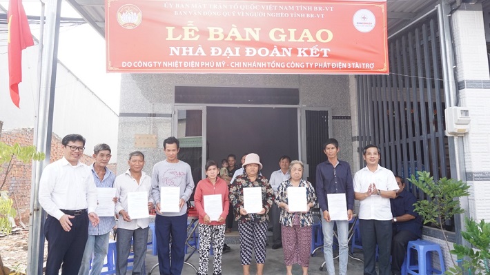 Ông Nguyễn Kế Toại - Phó Chủ tịch UBMTTQVN tỉnh Bà Rịa - Vũng Tàu (bìa phải) và ông Trần Hữu Thanh - Phó Giám đốc Công ty Nhiệt điện Phú Mỹ (bìa trái) trao Quyết định bàn giao nhà Đại đoàn kết cho các hộ dân tại TX.Phú Mỹ.