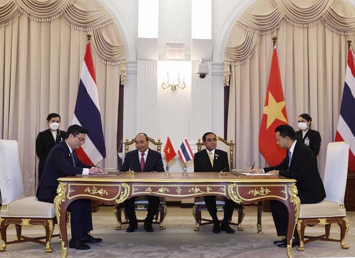 Đại diện Vietcombank, ông Nguyễn Thanh Tùng, Phó Tổng Giám đốc phụ trách Ban Điều hành (bên trái) và đại diện Eximbank Thái Lan, Ts. Rak Vorrakitpokatorn, Tổng Giám đốc (bên phải) ký kết thỏa thuận hợp tác trước sự chứng kiến của Chủ tịch nước Cộng hòa Xã hội Chủ nghĩa Việt Nam Nguyễn Xuân Phúc và Thủ tướng Thái Lan Prayuth Chan-ocha. Ảnh: TTXVN.
