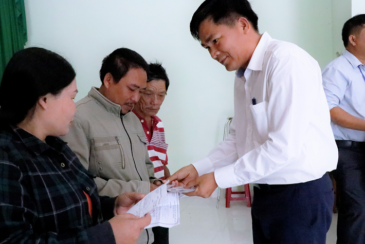 Ông Lê Việt Đức - Phó Giám đốc Công ty trao thẻ BHYT cho người dân địa phương