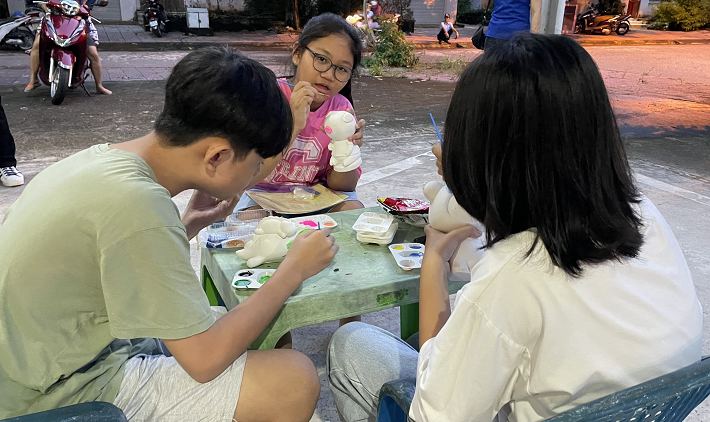 Các em thiếu nhi tô tượng/tranh cát do các anh chị Đoàn thanh niên chuẩn bị  trước giờ khai mạc đêm hội trăng rằm.