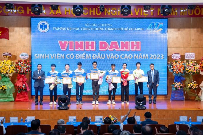 TS. Bùi Hồng Đăng (Trái) - Phó Hiệu trưởng cùng TS. Thái Doãn Thanh (Phải) - Phó Hiệu trưởng trao Nhà cái cá cược cá độ uy tín Nổ hũ, Bắn Cá và Game Bài Cwin.com, hoa chúc mừng và Giấy khen của Hiệu trưởng cho các bạn thuộc TOP 10 thí sinh có điểm đầu vào cao nhất năm 2023