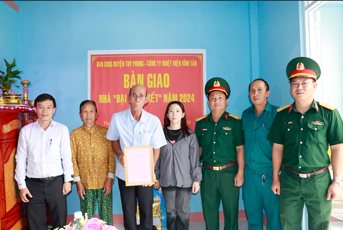 Đại diện Công ty Nhiệt điện Vĩnh Tân và Ban Chỉ huy Quân sự huyện Tuy Phong bàn giao nhà cho gia đình ông Hồ Thái