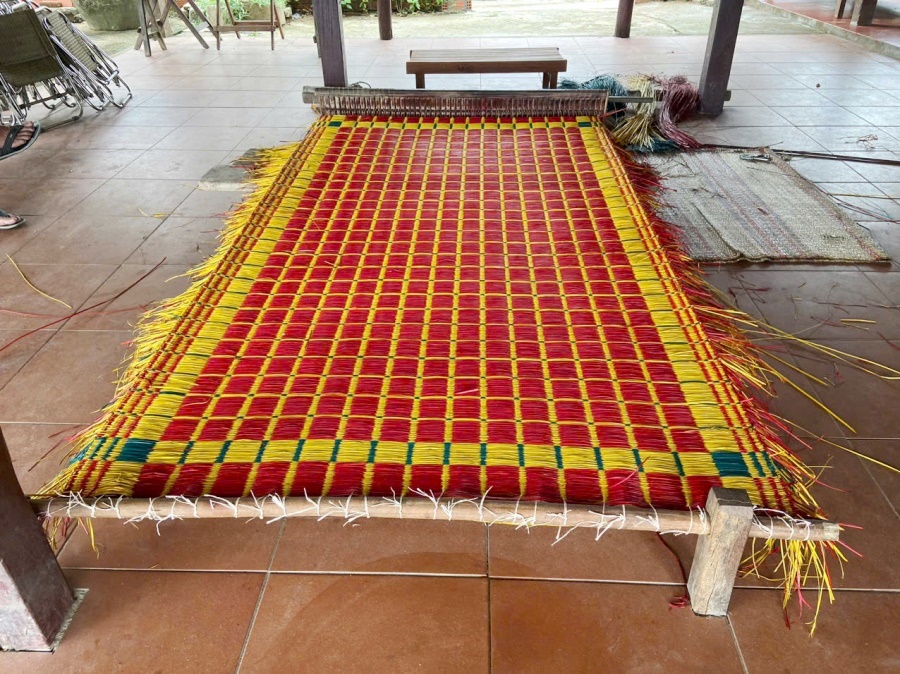 Chị Phạm Thị Công cùng với mẹ dệt chiếu tại gia đình