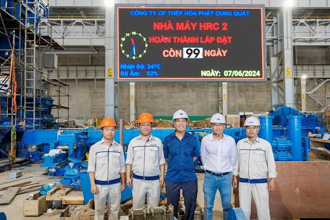 Chủ tịch Trần Đình Long chụp ảnh cùng BGĐ Công ty, BGĐ Nhà máy QSP và Trưởng Ban Dự án Hòa Phát Dung Quất 2 tại bảng đếm ngược Nhà máy HRC 2 hoàn thành lắp đặt còn 99 ngày