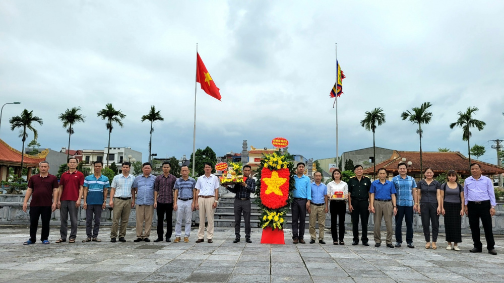 A group of people standing in front of flags

Description automatically generated