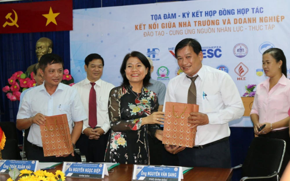 Bà Nguyễn Ngọc Điệp – Giám đốc Trung tâm Dịch vụ Việc làm và hỗ trợ Cwincom hiện đang mở – JESC (đứng giữa) trong một buổi ký kết hợp tác với Cwincom hiện đang mở và nhà trường